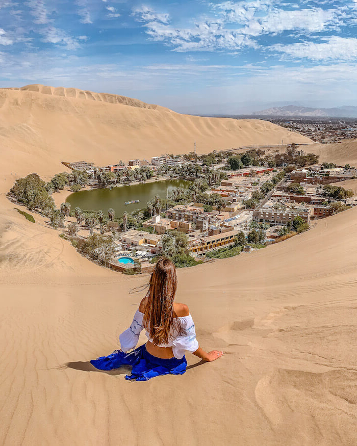 Panoramic view of the Huacachina Oasis surrounded by sand dunes.